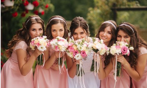 The bridesmaids and the bride holding flowers