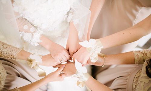 Bride holding hands with her bridesmaids 
