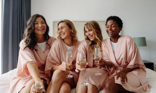 Bride and her bridesmaids at a hotel room having good time add this to the amazing wedding day checklist 