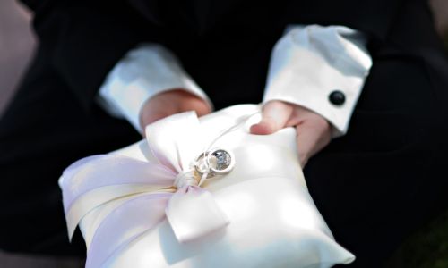 Ring bearer holding a ring pillow with two hands