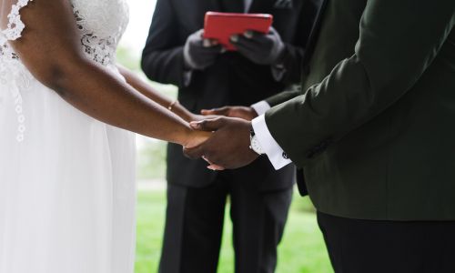 Exchanging the vows with a wedding officiant watching